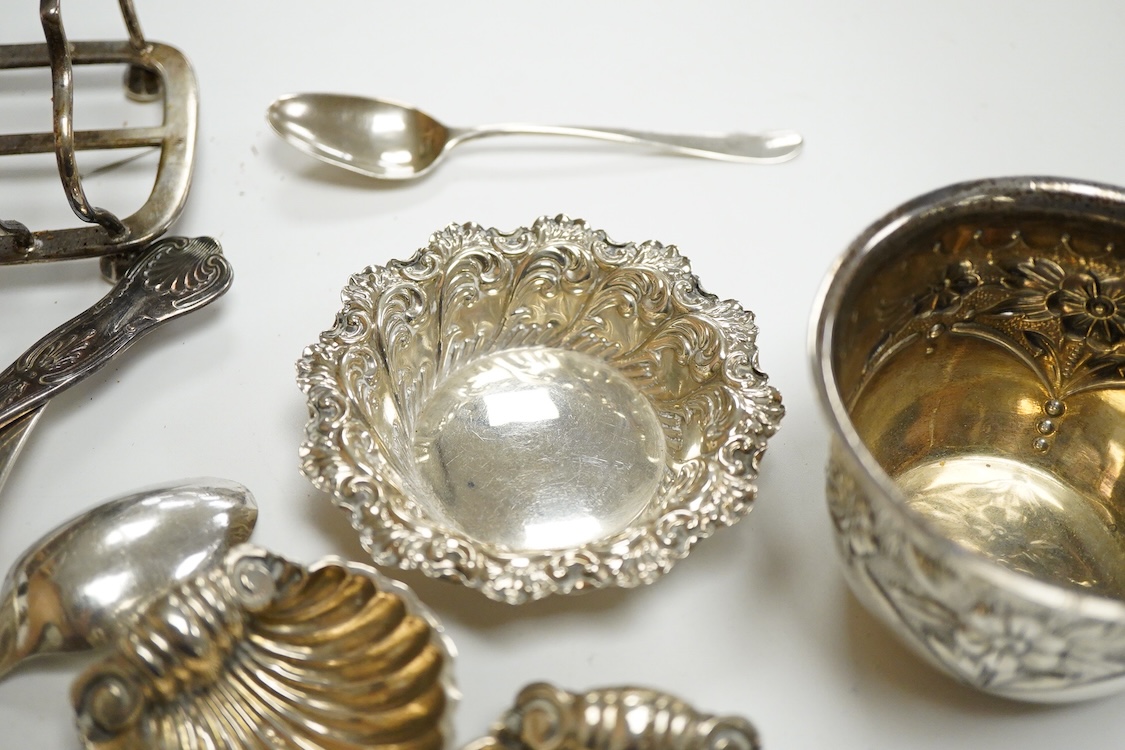 A collection of small silver, to include a late Victorian seven bar toast rack, by Edward Gilbert, London, 1887, length 13.3cm, a late Victorian bowl, pair of shell salts, nut dish, egg cup, Georgian chamberstick(part of